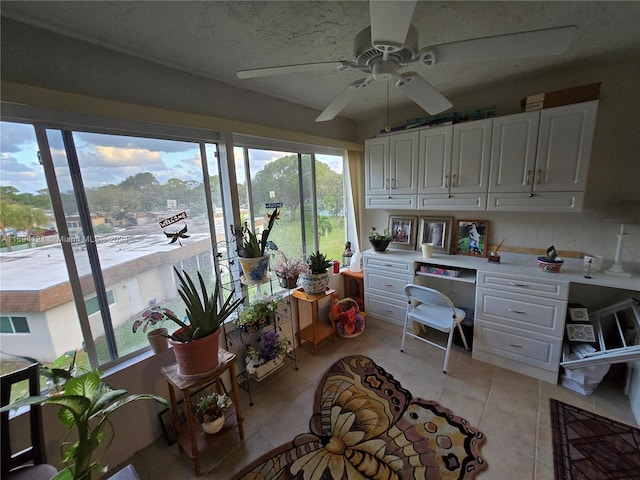 office featuring light tile patterned flooring, a healthy amount of sunlight, ceiling fan, and built in desk