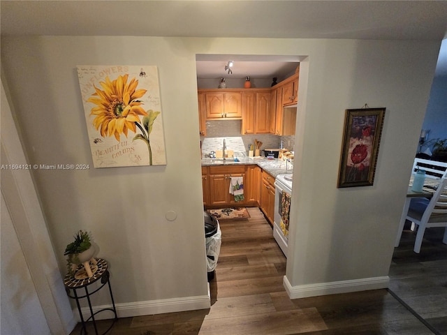 kitchen featuring sink, white electric range, light stone counters, dark hardwood / wood-style floors, and backsplash