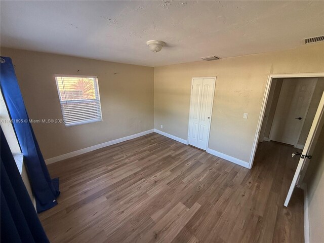 unfurnished bedroom with a closet and hardwood / wood-style floors