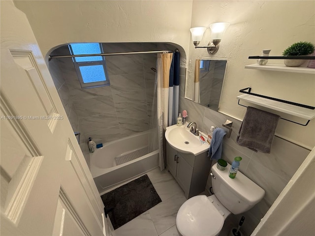 full bathroom featuring toilet, vanity, tile walls, and shower / bath combo