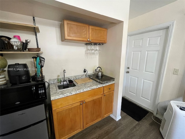 kitchen featuring dark wood-type flooring, sink, and light stone counters