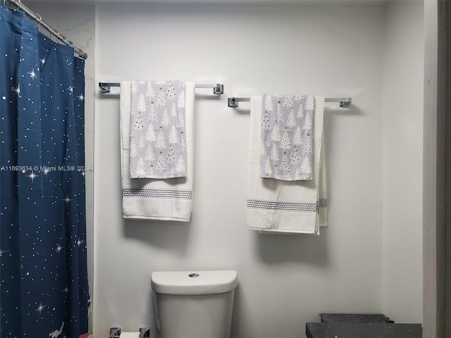 bathroom with a shower with shower curtain and toilet