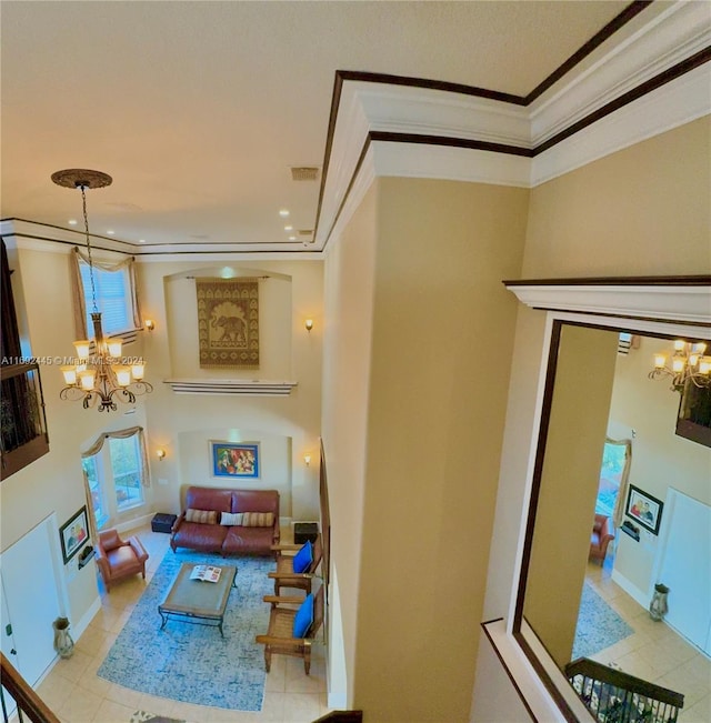 living room with light tile patterned floors, a chandelier, and ornamental molding