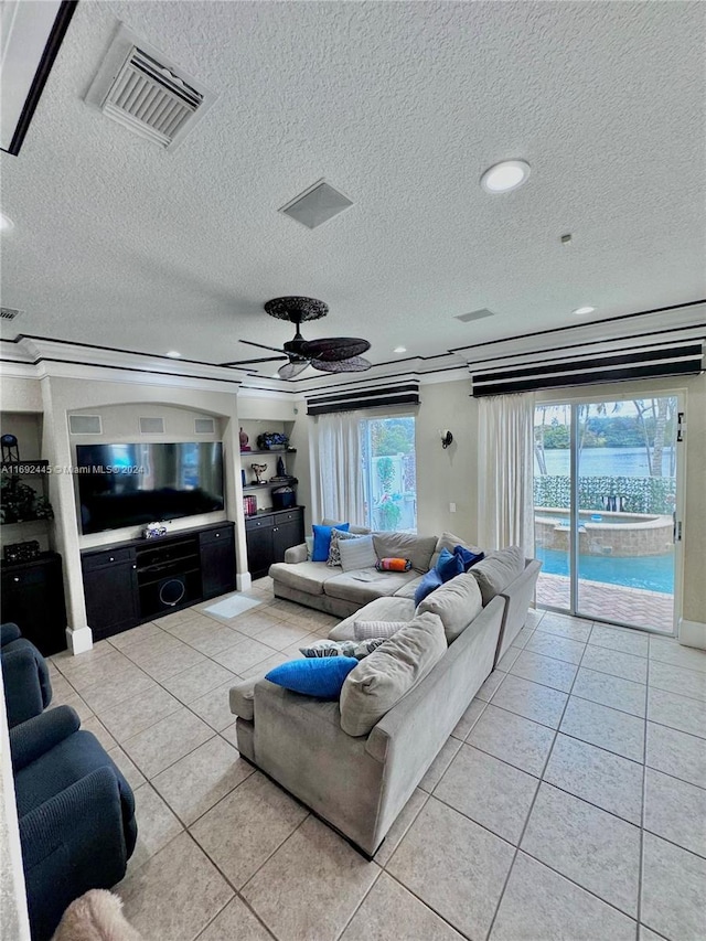 living room featuring ceiling fan, light tile patterned floors, and a textured ceiling