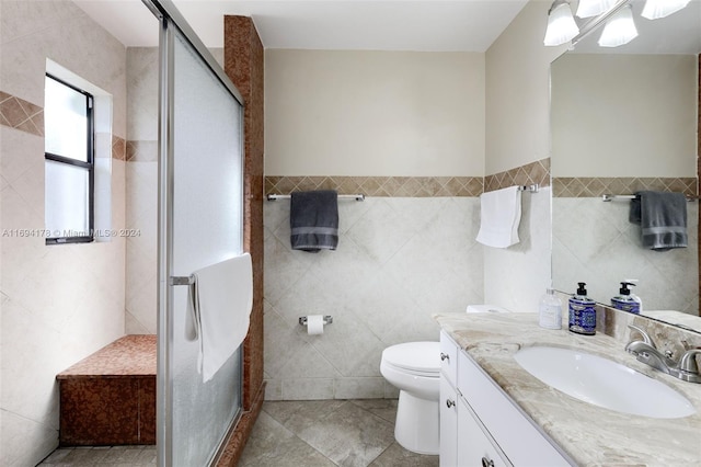 bathroom featuring vanity, tile patterned flooring, toilet, tile walls, and an enclosed shower