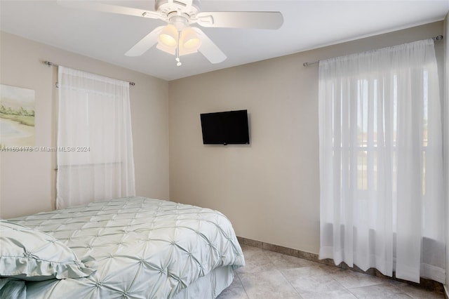 tiled bedroom featuring ceiling fan