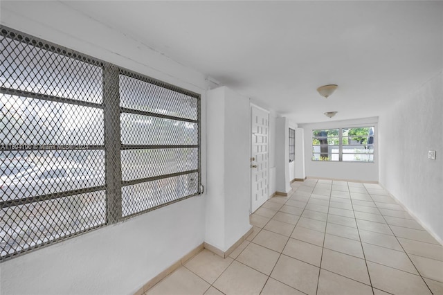 hallway featuring french doors and light tile patterned flooring