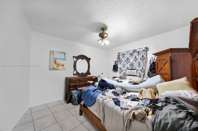 bedroom with cooling unit, light tile patterned flooring, and a textured ceiling