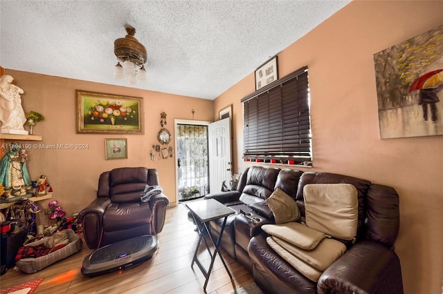 living room with a textured ceiling and light wood-type flooring