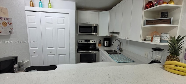 kitchen featuring white cabinets, light stone counters, sink, and stainless steel appliances