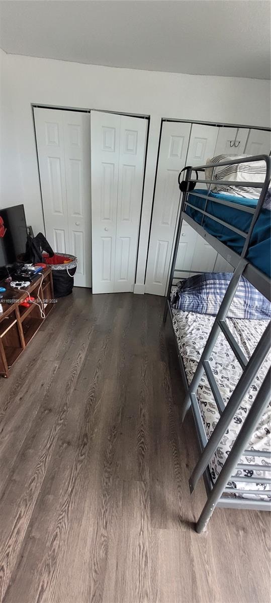 bedroom with hardwood / wood-style flooring and multiple closets