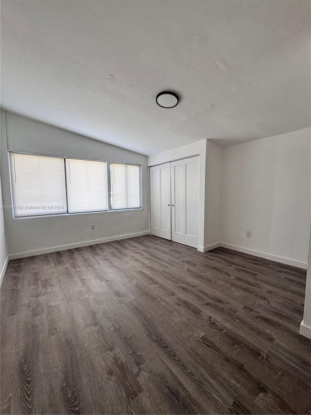 unfurnished bedroom with a closet, dark wood-type flooring, and a textured ceiling