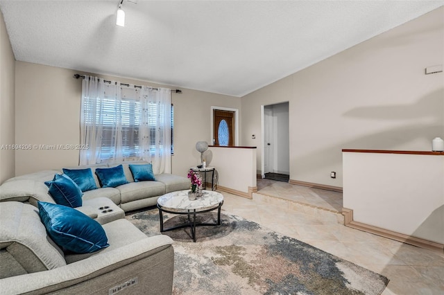 living room with baseboards, light tile patterned floors, a textured ceiling, and lofted ceiling