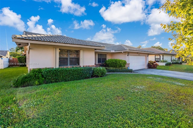 ranch-style house with a garage and a front lawn