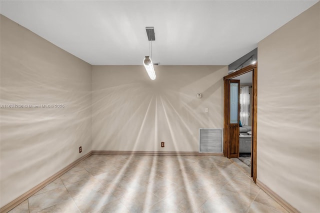 unfurnished room with visible vents and baseboards