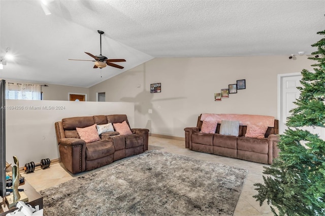 living room with ceiling fan, lofted ceiling, a textured ceiling, and light tile patterned floors