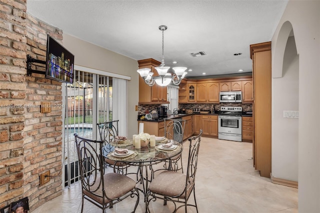 tiled dining area featuring a chandelier