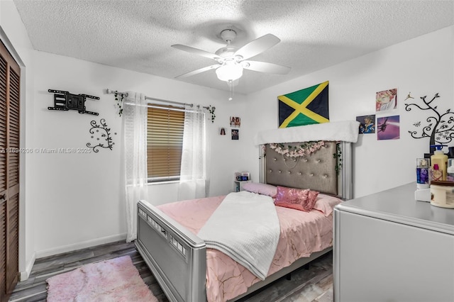 bedroom featuring a ceiling fan, baseboards, wood finished floors, a closet, and a textured ceiling