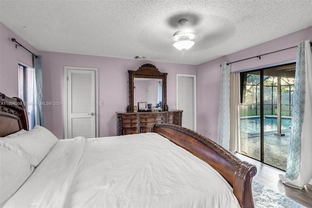 bedroom with access to exterior, a textured ceiling, ceiling fan, hardwood / wood-style flooring, and a closet