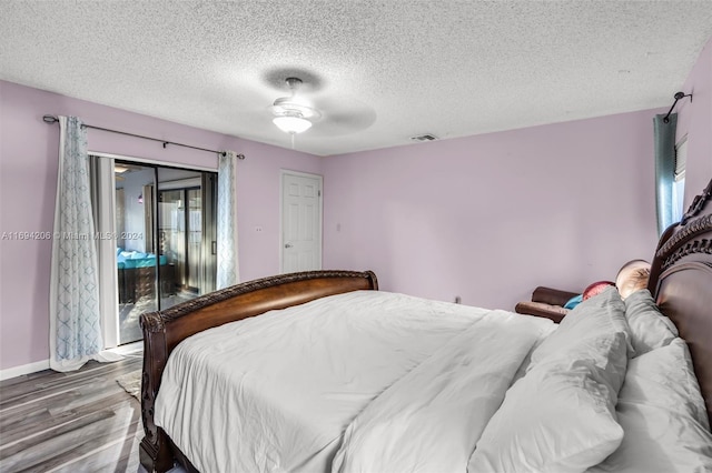 bedroom with hardwood / wood-style flooring, ceiling fan, a textured ceiling, and access to outside