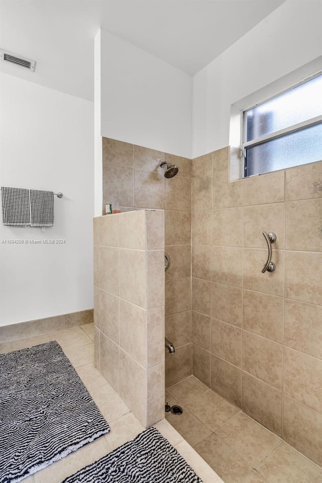 bathroom featuring tile patterned floors and a tile shower