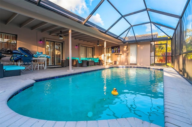 pool with glass enclosure, a patio, ceiling fan, and outdoor lounge area