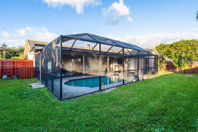 rear view of house with glass enclosure, a fenced in pool, a fenced backyard, a patio area, and a lawn