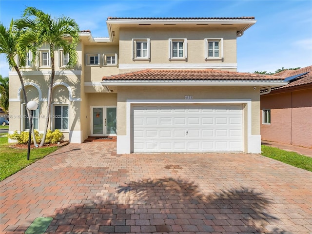 mediterranean / spanish home with french doors and a garage