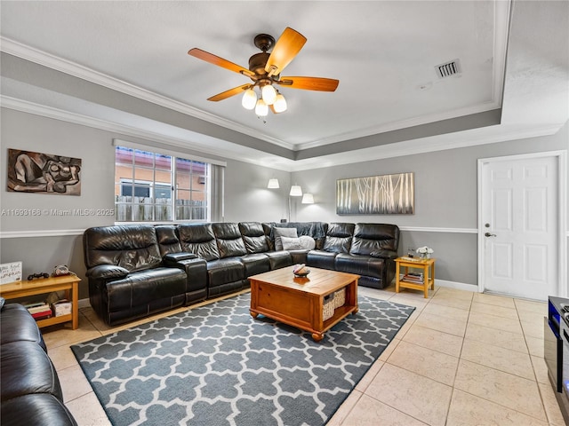 living room featuring a raised ceiling, ceiling fan, light tile patterned flooring, and ornamental molding