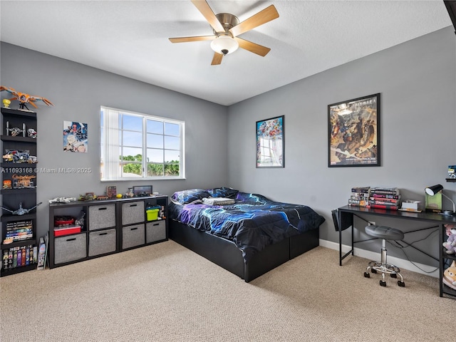 bedroom with ceiling fan, carpet floors, and a textured ceiling