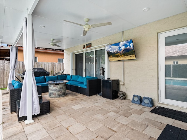 view of patio with ceiling fan and an outdoor living space with a fire pit