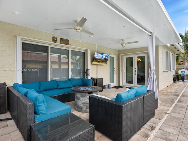 view of patio / terrace with french doors and an outdoor living space with a fire pit