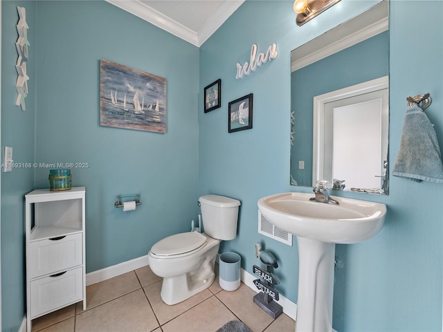 bathroom with tile patterned flooring, toilet, ornamental molding, and sink