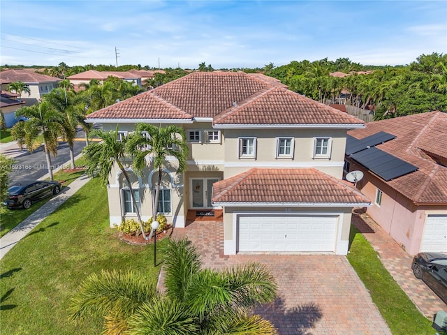 mediterranean / spanish house with a front lawn and a garage