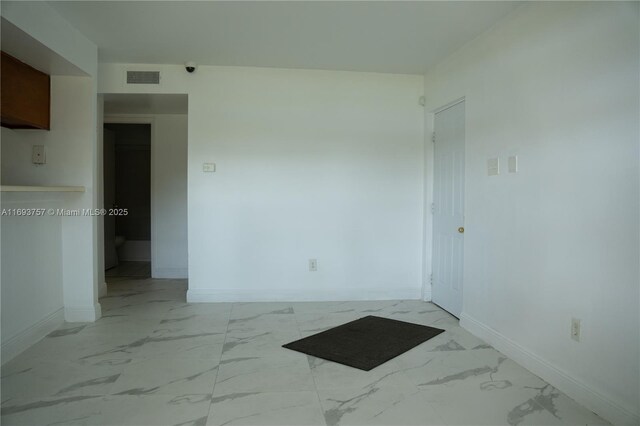 spare room featuring visible vents, baseboards, and marble finish floor