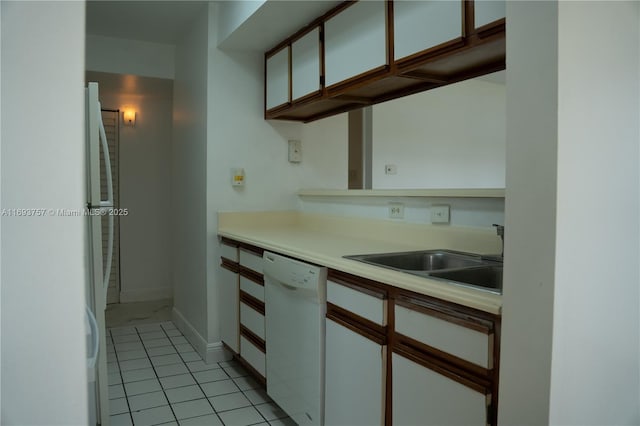 kitchen featuring dishwasher, light countertops, white cabinetry, and a sink