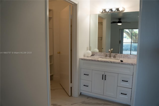 bathroom with marble finish floor, vanity, and a ceiling fan