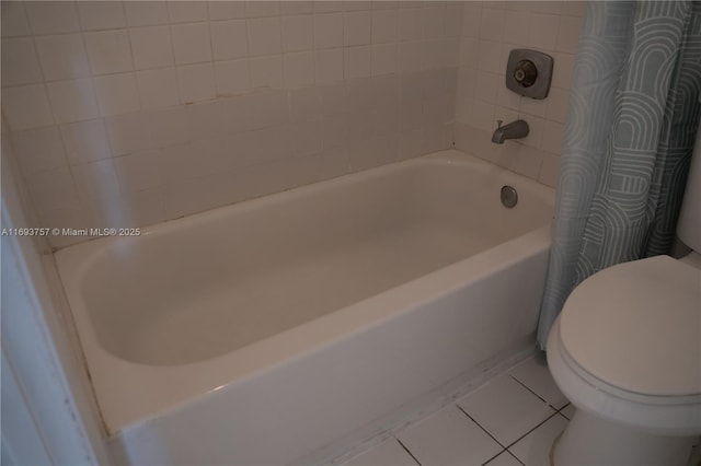 bathroom with tile patterned flooring, toilet, and a bathtub