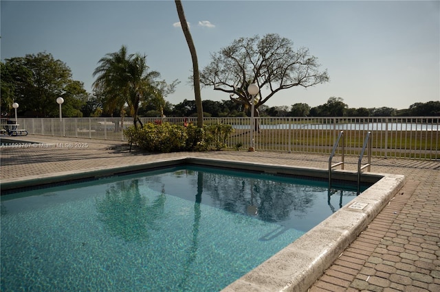 community pool with a patio and fence