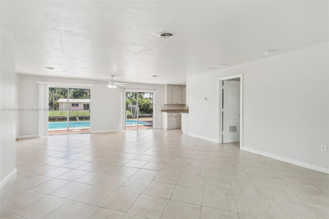 unfurnished room with ceiling fan and light tile patterned flooring