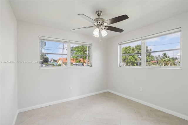 tiled spare room with a wealth of natural light and ceiling fan