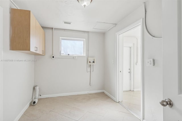 washroom featuring cabinets, hookup for a washing machine, and light tile patterned floors