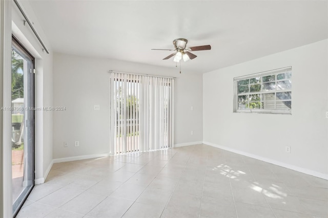 spare room with ceiling fan and light tile patterned flooring