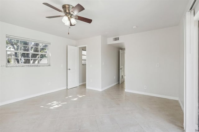 unfurnished room with light tile patterned floors and ceiling fan