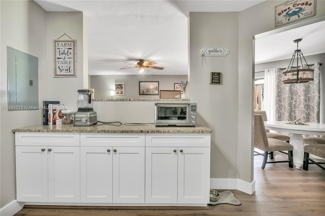 kitchen featuring white cabinetry, hanging light fixtures, and wood-type flooring