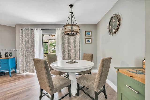 dining room with a notable chandelier and light wood-type flooring