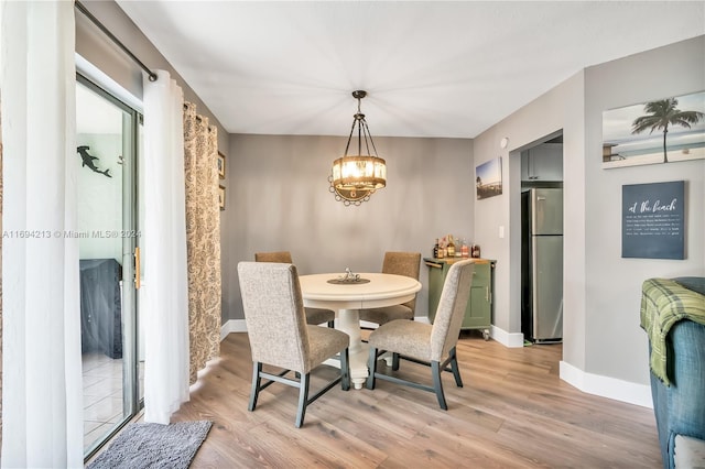 dining room with a notable chandelier and light wood-type flooring