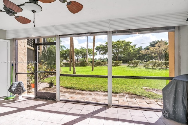 unfurnished sunroom with ceiling fan