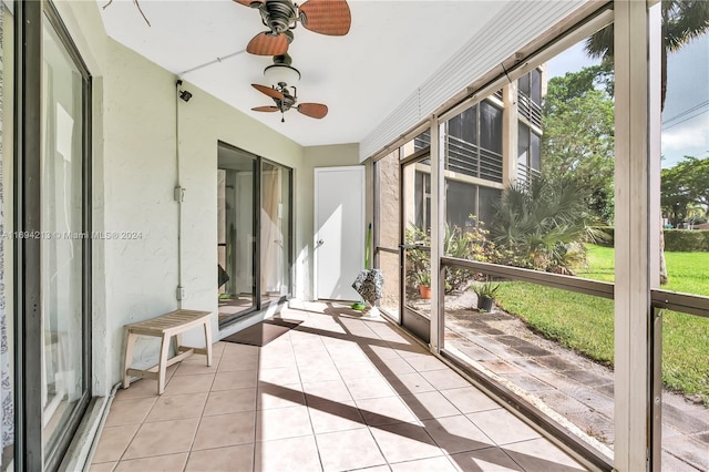 unfurnished sunroom featuring ceiling fan and a healthy amount of sunlight