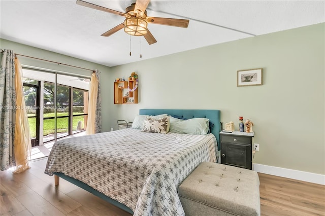 bedroom with hardwood / wood-style floors, ceiling fan, and access to exterior